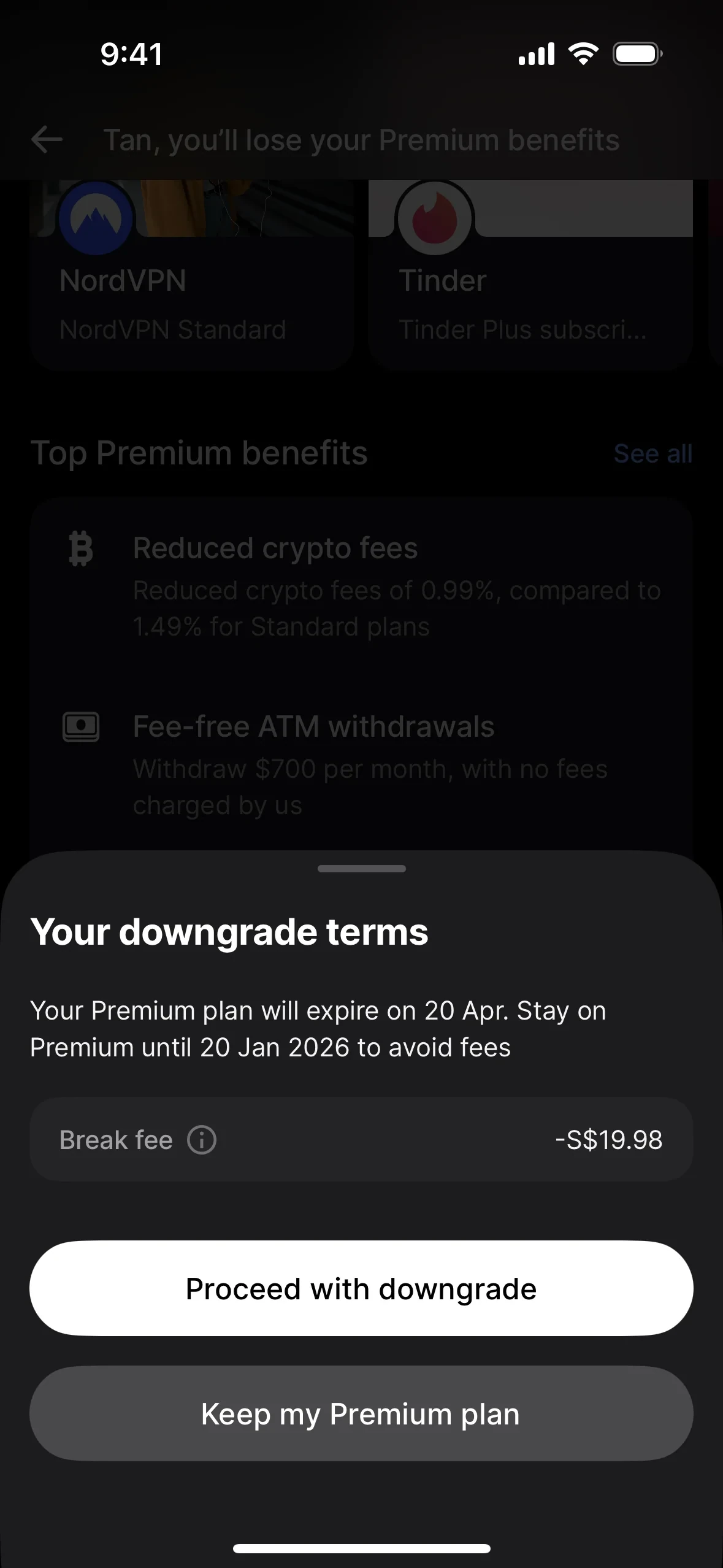 Your downgrade terms sheet stating the Premium plan will expire on 20 Apr and to stay on Premium until 20 Jan 2026 to avoid fees, with a Break fee row showing minus S dollar 19.98, above a white Proceed with downgrade button and a grey Keep my Premium plan button